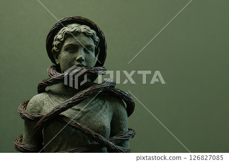 The statue of a woman is entangled in branches. Space for text. 126827085