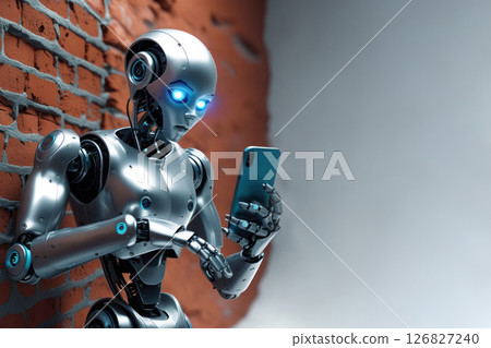 A robot with blue eyes looks at a phone near a brick wall. Space for text. A robot with blue eyes looks at a phone near a brick wall. Space for text. 126827240