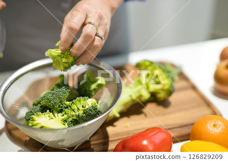 Hands of a middle-aged woman cutting vegetables 126829209
