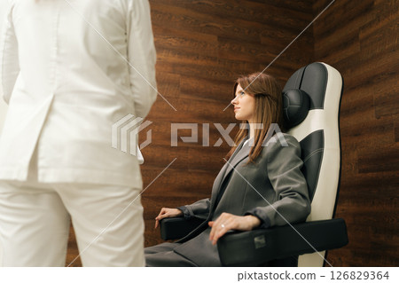 Rear view of medical therapist explaining pelvic floor muscle training, providing professional guidance, patient sitting on chair during consultation. Concept of innovative healthcare technology. Rear view of medical therapist explaining pelvic floor muscle training, providing professional guidance, patient sitting on chair during consultation. Concept of innovative healthcare technology. 126829364