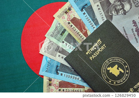 Bangladeshi taka money bills in big amount and passport lies on Bangladesh flag close up Bangladeshi taka money bills in big amount and passport lies on Bangladesh flag close up 126829450