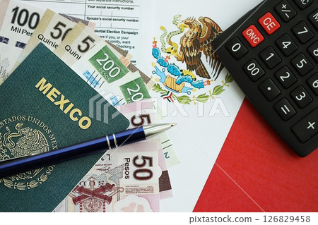 Mexican pesos money bills in big amount lies on table with pen, calculator, passport and tax forms Mexican pesos money bills in big amount lies on table with pen, calculator, passport and tax forms 126829458