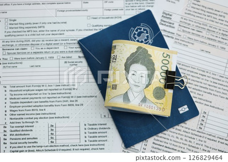 South Korean won money bills in big amount lies on table with passport and tax forms close up 126829464