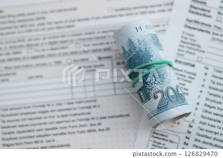 North Korean won money bills in big amount lies on table with tax forms close up 126829470