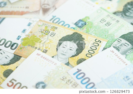 South Korean won money bills in big amount lies on white color table close up South Korean won money bills in big amount lies on white color table close up 126829473