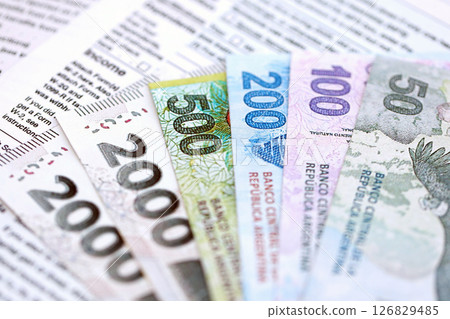 Argentine pesos money bills in big amount lies on table with pen and tax forms close up 126829485