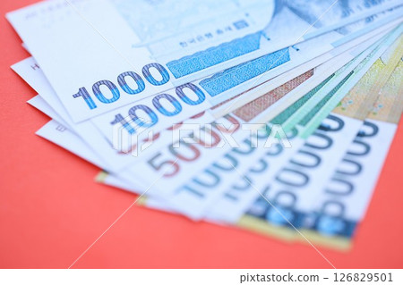 South Korean won money bills in big amount lies on red color table close up 126829501