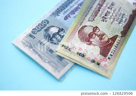Bangladeshi taka money bills in big amount lies on teal color table close up 126829506