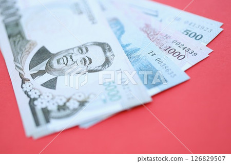 North Korean won money bills in big amount lies on red color table close up 126829507