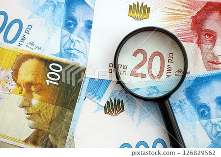 Israel New Shekels banknotes and magnifying glass. The current Israel money bills with loupe Israel New Shekels banknotes and magnifying glass. The current Israel money bills with loupe 126829562