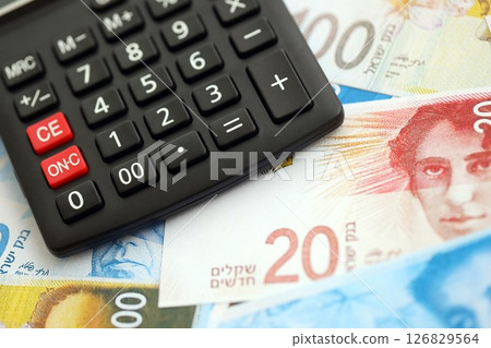 Israel New Shekels banknotes and calculator. The current Israel money bills and calc lies on table 126829564