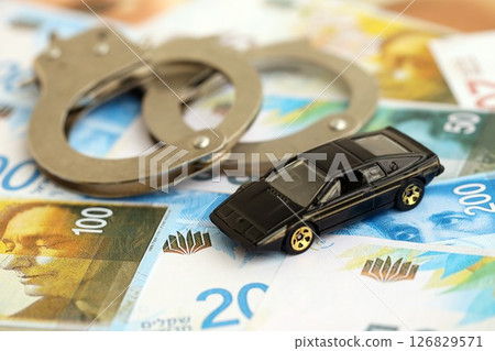 Israel New Shekels banknotes and toy car with handcuffs. The current Israel money bills and car 126829571