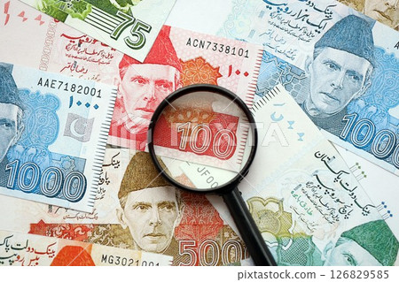 Pakistan rupees banknotes and magnifying glass. The current Pakistan money bills with loupe Pakistan rupees banknotes and magnifying glass. The current Pakistan money bills with loupe 126829585