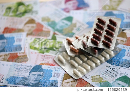 Pakistan rupees banknotes and medicine pills. Pakistan money bills with drugs close up 126829589