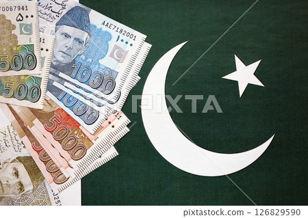 Pakistan rupees banknotes on Pakistani flag background. The current Pakistan money bills Pakistan rupees banknotes on Pakistani flag background. The current Pakistan money bills 126829590