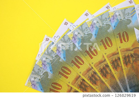 Swiss franc banknotes on yellow. The current francs money bills lies on table in big amount 126829619