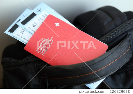 Swiss passport and avia tickets on travel bag. Pass and boarding tokens on bag close up 126829628