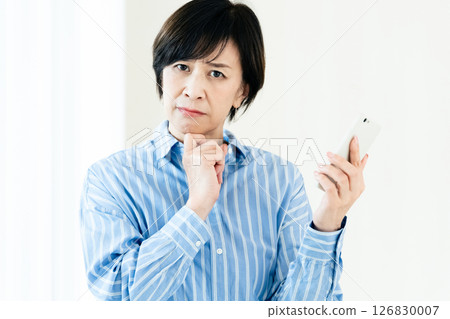 A middle-aged woman with a smartphone 126830007