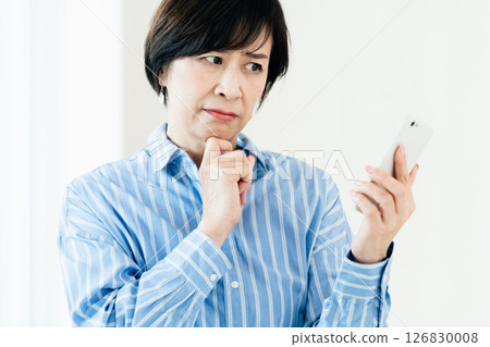 A middle-aged woman with a smartphone A middle-aged woman with a smartphone 126830008