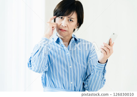 一位中年婦女拿著智慧型手機 126830010