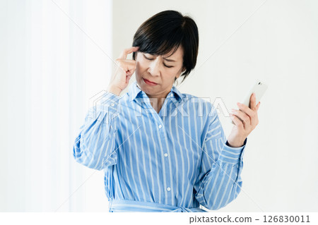 一位中年婦女拿著智慧型手機 126830011