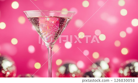 Martini glass with sparkling drink and bokeh lights on pink background, festive atmosphere. Holiday celebration and party concept Martini glass with sparkling drink and bokeh lights on pink background, festive atmosphere. Holiday celebration and party concept 126830058
