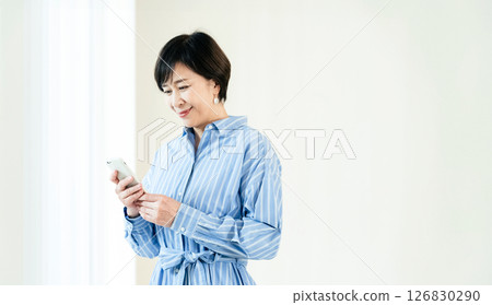 一位操作智能手機的中年婦女 126830290