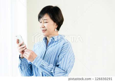 一位操作智能手機的中年婦女 126830291