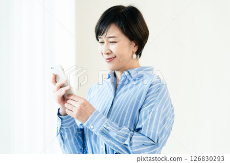 A middle-aged woman who operates a smartphone 126830293