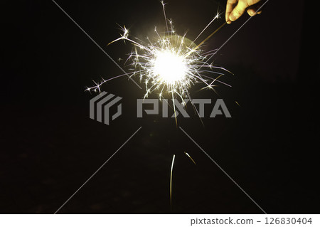 Sparks from hand-held fireworks and hands Sparks from hand-held fireworks and hands 126830404