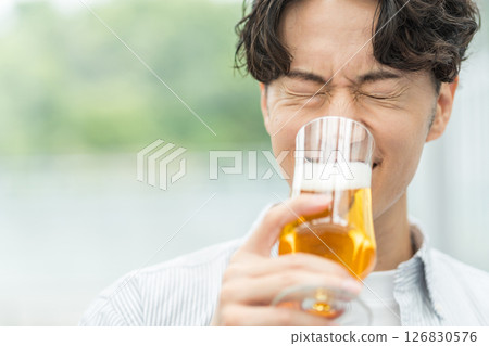 一名男子正在喝美味的啤酒。 126830576