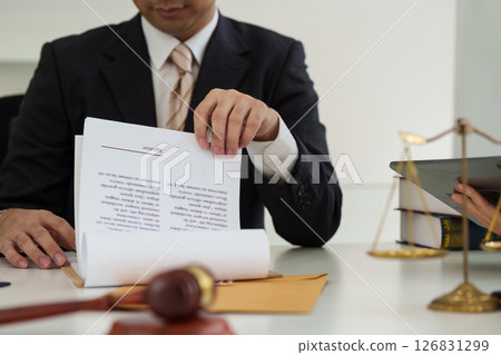 Document Review and Legal Insights. A lawyer analyzing paperwork while preparing for an important consultation. Document Review and Legal Insights. A lawyer analyzing paperwork while preparing for an important consultation. 126831299