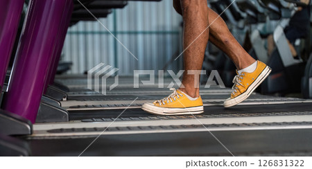 Workout and Fitness. Close-up of a person walking on a treadmill in bright yellow sneakers. 126831322