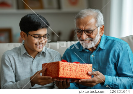 Celebrating generational bonds grandfather and grandson exchange gifts at home Celebrating generational bonds grandfather and grandson exchange gifts at home 126831644