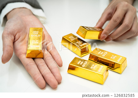 Asian woman holding gold bar in finance business. 126832585