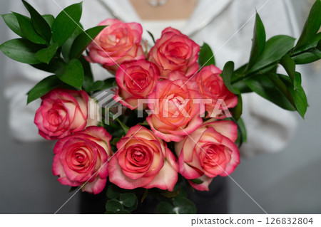 girl holding a bouquet of pink roses in her hands girl holding a bouquet of pink roses in her hands 126832804