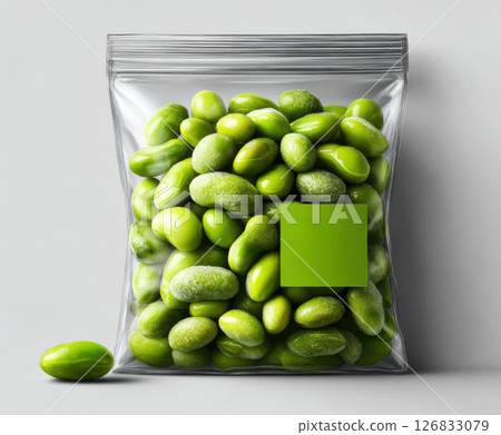 Transparent plastic bag filled with frozen edamame, featuring green label, isolated on white background. 126833079