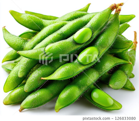 Fresh green edamame pods stacked with some beans visible 126833080