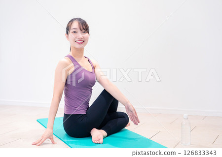 Sporty woman doing yoga coaching at gym 126833343