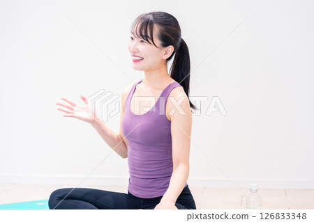 Sporty woman doing yoga coaching at gym 126833348