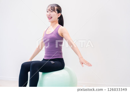 Sporty woman doing yoga coaching at gym 126833349