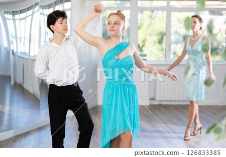 Passionate teen dancers, girl and boy practicing ballroom dancing in studio 126833385