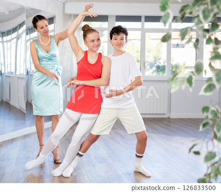Teenage boy and girl performing waltz in pair during dance lesson Teenage boy and girl performing waltz in pair during dance lesson 126833500