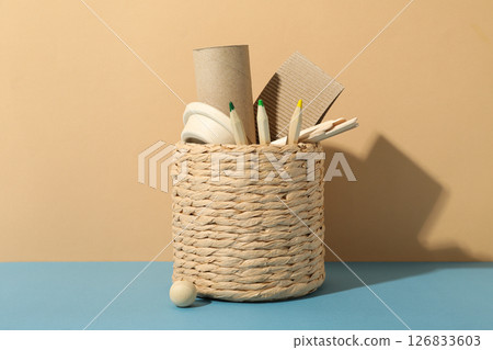 Handmade basket with paper things and pencils on beige background 126833603
