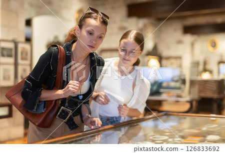 Woman and teenage girl looking at exhibit in museum display 126833692