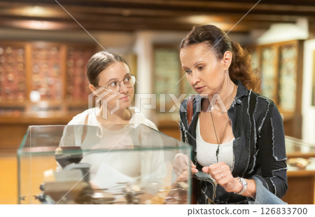 Young woman with teen daughter walk around museum, view clock Young woman with teen daughter walk around museum, view clock 126833700