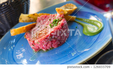 Image of delicious veal steak tartar served at plate with fried bread 126833709