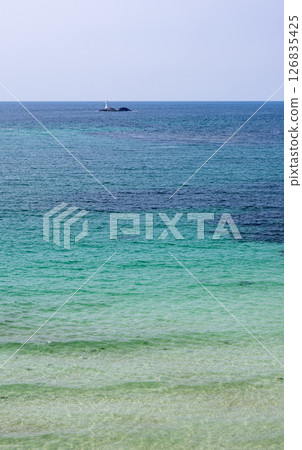 Waves crashing on the beautiful sandy beach of Tsunoshima and the Tsunoshima Bridge 126835425