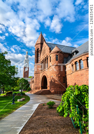 The historic Billings Library, built in red sandstone with Romanesque Revival architecture, stands beside the white clock tower of Ira Allen Chapel on the University of Vermont campus in Burlington The historic Billings Library, built in red sandstone with Romanesque Revival architecture, stands beside the white clock tower of Ira Allen Chapel on the University of Vermont campus in Burlington 126835451