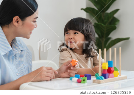 toddler girl and mother playing educational wooden toy at home 126835539
